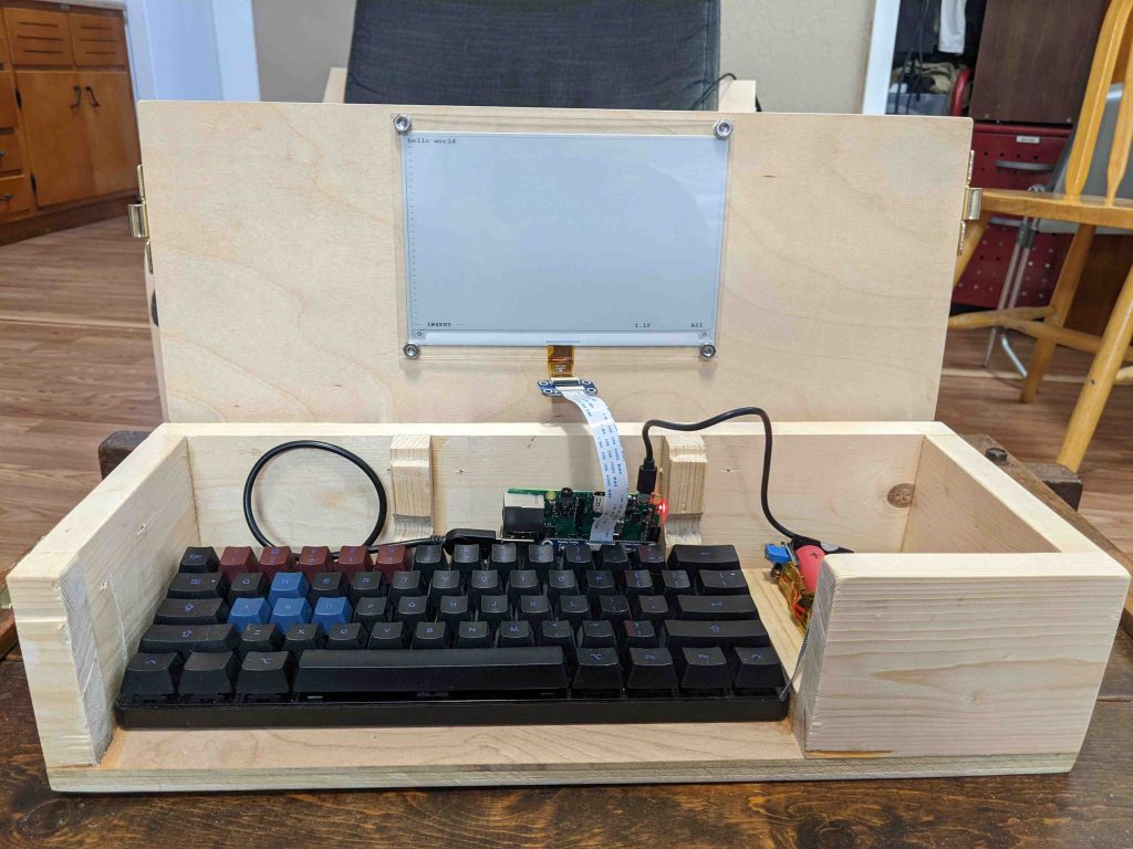 a wooden box with a keyboard inside and an e-ink screen mounted to it