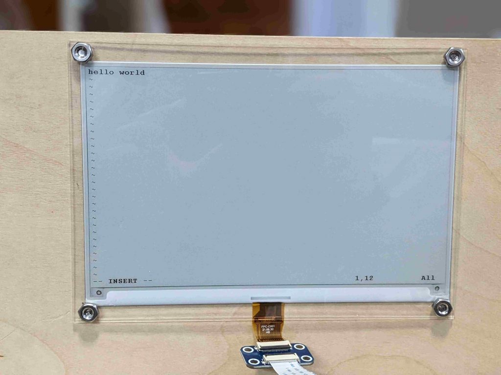 an e-ink screen reading "hello world"